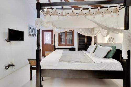 a bedroom with a black and white canopy bed at Casa Magnolia Communal Pool and Outdoor Shower in Kralendijk
