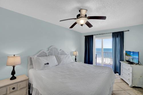 a bedroom with a white bed and a ceiling fan at Ocean House 2503 in Gulf Shores