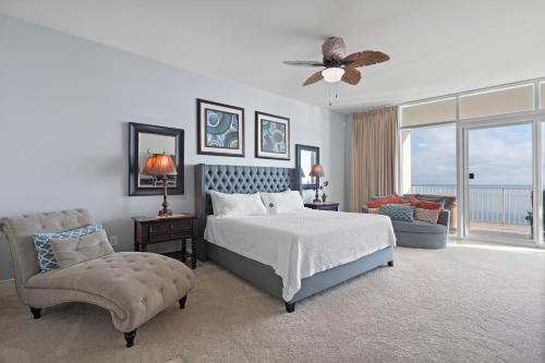 a bedroom with a bed and a chair and a window at Turquoise Place By Liquid Life in Orange Beach