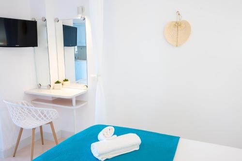 Zimmer mit einem Bett, einem Stuhl und einem Spiegel in der Unterkunft Eleftheria's Place in Patmos