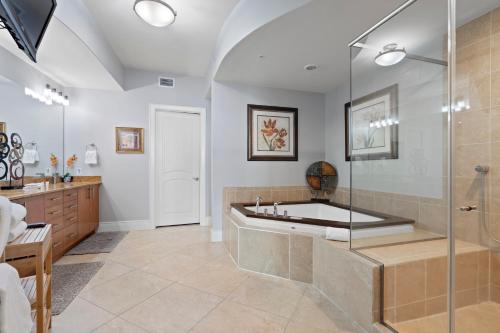 a bathroom with a tub and a glass shower at Turquoise Place By Liquid Life in Orange Beach