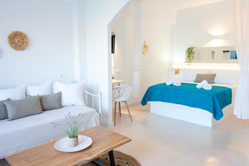 ein weißes Schlafzimmer mit einem Bett und einem Tisch in der Unterkunft Eleftheria's Place in Patmos