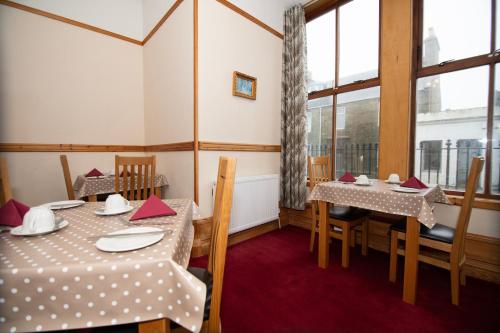 una sala da pranzo con due tavoli e una finestra di Alder Lodge Guest House a Lerwick