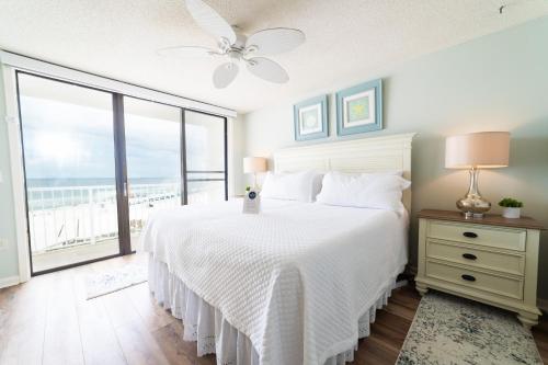 a bedroom with a white bed and a large window at Seaside Beach Racquet 3504 in Orange Beach
