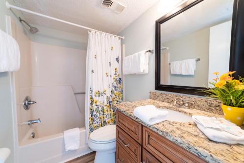 a bathroom with a sink and a toilet and a mirror at Seaside Beach Racquet 3504 in Orange Beach
