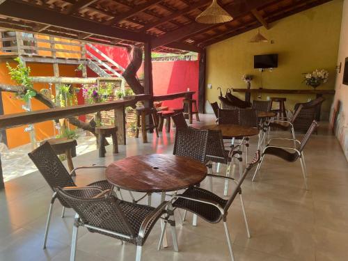 Pousada Flor de Pequi في سيرا دو سيبو: مطعم فيه طاولات وكراسي في الغرفة