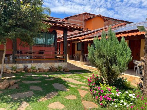 une maison avec un jardin en face dans l'établissement Pousada Flor de Pequi, à La Serra do Cipo
