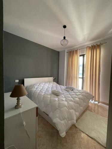 - une chambre avec un lit blanc et une fenêtre dans l'établissement Tirana Central Home, à Tirana