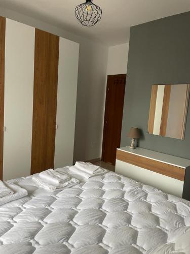- une chambre avec un grand lit blanc dans l'établissement Tirana Central Home, à Tirana