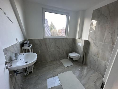 a bathroom with a sink and a toilet and a window at Holiday Dream House-B for 6 Persons in Tornesch
