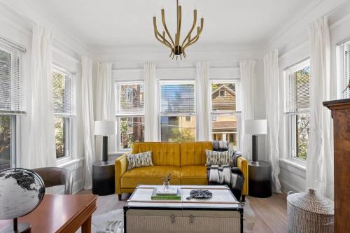 a living room with a yellow couch and windows at Field of Light in Atlanta