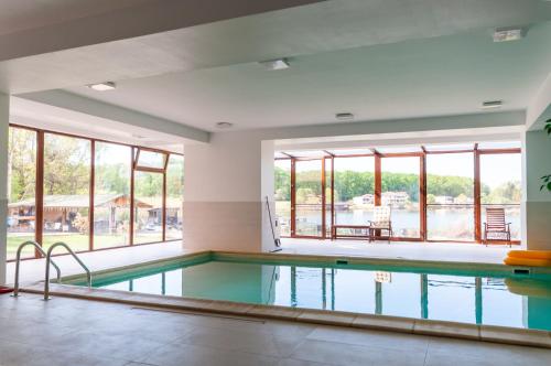 a swimming pool with a view of the water at Snagov Lake Apartments - Club Lac Snagov in Turbaţi