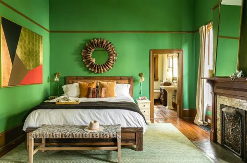 a green bedroom with a bed and a mirror at Pecan Park in Atlanta