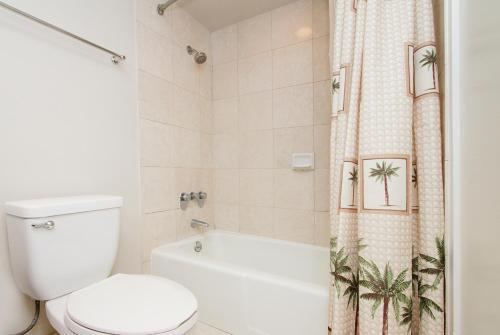La salle de bains est pourvue de toilettes et d'un rideau de douche avec des palmiers. dans l'établissement Special rate close to the beach L214, à Honolulu