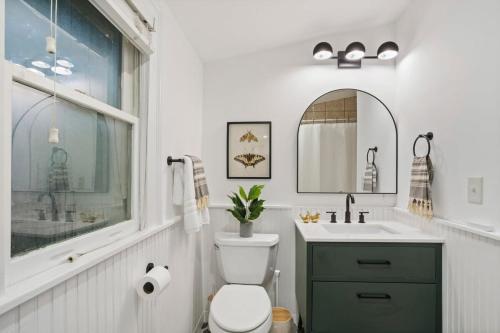 uma casa de banho com um WC, um lavatório e uma janela em Majic Cottage em Atlanta