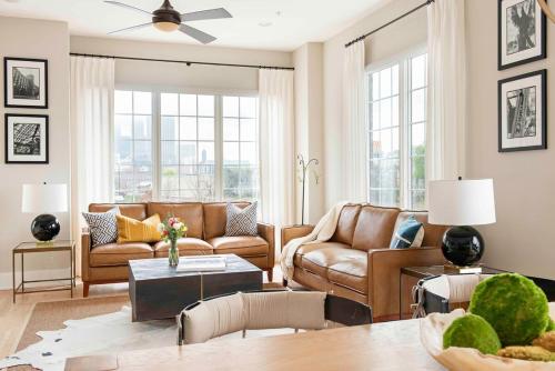a living room with brown leather furniture and windows at Sky's the Limit in Atlanta