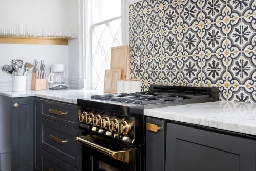 a kitchen with a black stove and a patterned wall at Solar Flair in Atlanta