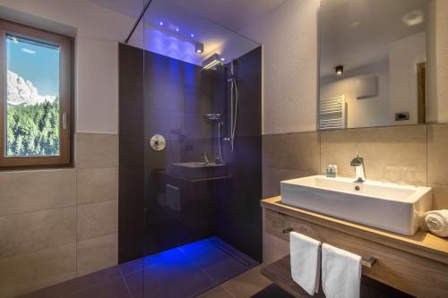 a bathroom with a sink and a shower at Chalet Prades Dolomiti Lodges in La Villa