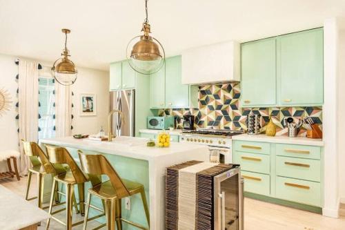 a kitchen with green cabinets and a kitchen island with chairs at Penthouse Lux in Atlanta