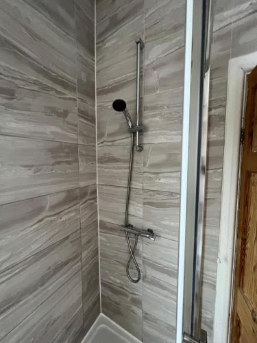 a shower with a shower head in a bathroom at Comfortable Double Bed in Coventry
