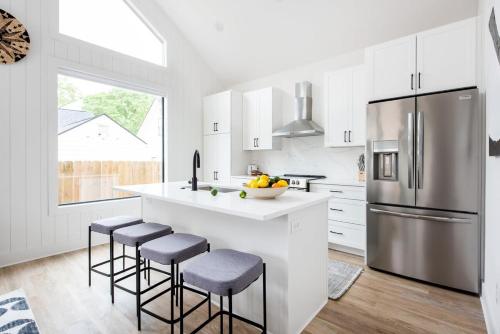 a kitchen with white cabinets and a stainless steel refrigerator at Dapper Dan in Atlanta