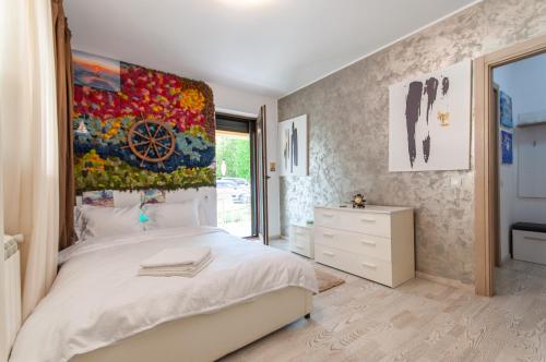 a bedroom with a bed with a large painting on the wall at Snagov Lake Apartments - Club Lac Snagov in Turbaţi