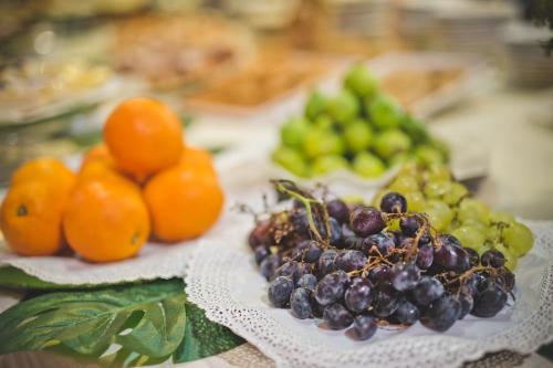 a plate of grapes and other fruits on a table at Albergo Athenaeum in Palermo