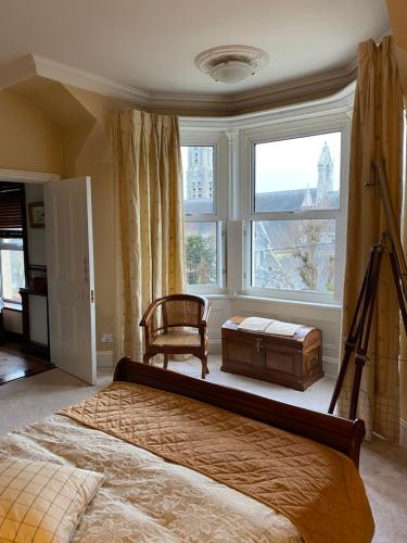 a bedroom with a bed and a chair and a window at Victorian Villa in New Ross