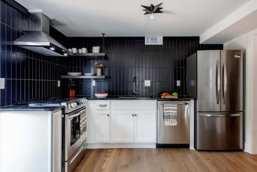 a kitchen with white cabinets and a stainless steel refrigerator at Mic Drop in Atlanta