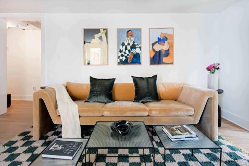a living room with a brown couch and some paintings at Mic Drop in Atlanta