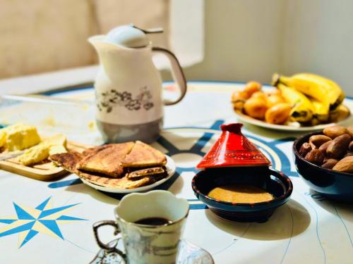 Hostel le Rhumel في قسنطينة: طاولة مليئة بأطباق الطعام وأكواب القهوة