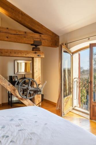 une chambre avec un lit et une grande fenêtre dans l'établissement Grande Maison de Charme a 5 mn du centre ville, à Narbonne