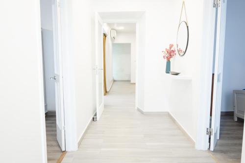 un pasillo con puertas blancas y un jarrón de flores en Casa da Alexandrina, en Algarvia