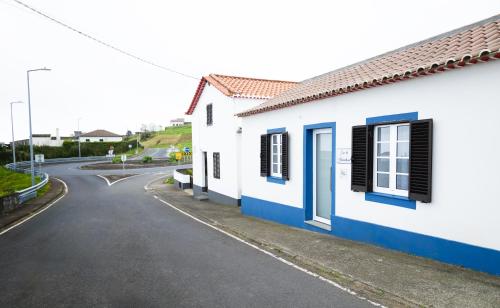 una casa bianca con finestre blu e una strada di Casa da Alexandrina ad Algarvia