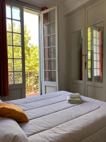 ein großes Bett in einem Zimmer mit einem großen Fenster in der Unterkunft Edificio Quijano - by Ale in Montevideo