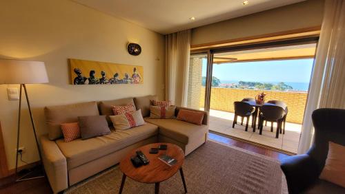 ein Wohnzimmer mit einem Sofa und einem Tisch in der Unterkunft Casa da Praia in Vila Nova de Gaia