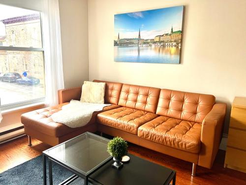 - un salon avec un canapé brun et une table en verre dans l'établissement Hamburg - Stylish Heritage Unit with Stewart Park View, à Perth