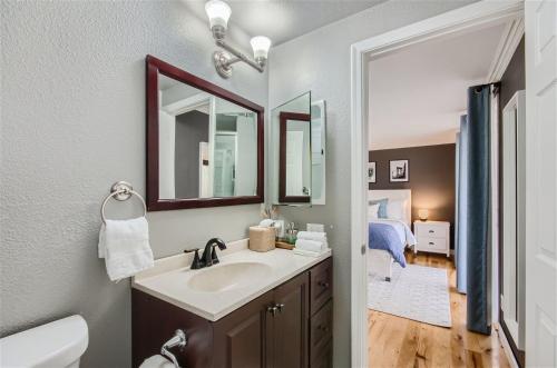 a bathroom with a sink and a mirror and a bedroom at Arizona Daydream with Private Pool plus EV Charger in Chandler