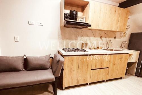 uma cozinha com um sofá, um lavatório e um fogão em Lotus Loft Itagui em Itagüí