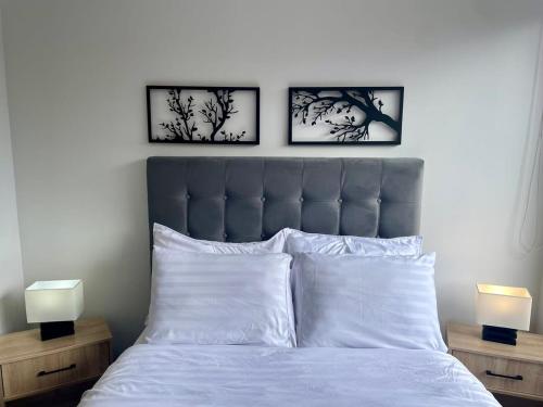 Una cama con tres cuadros en la pared. en Serenity Near Country Club - Loft Retreat, en Bogotá