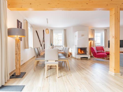 a living room with a table and chairs and a fireplace at Chalet Bergblick in Sankt Margarethen im Lungau