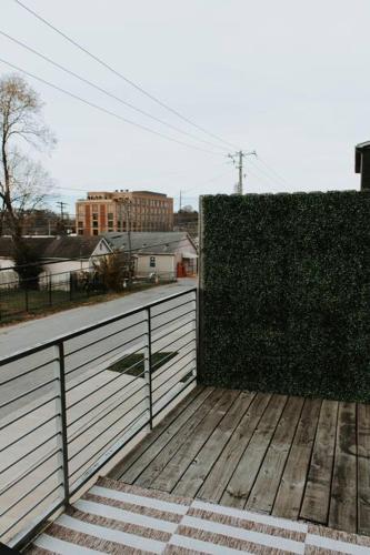a wooden deck with a fence and a hedge at Winner's Circle in The City in Lexington