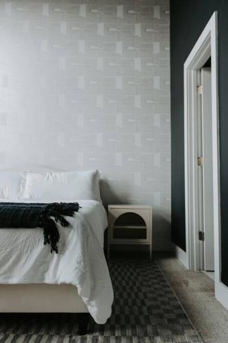a bedroom with a white bed and a fireplace at Winner's Circle in The City in Lexington