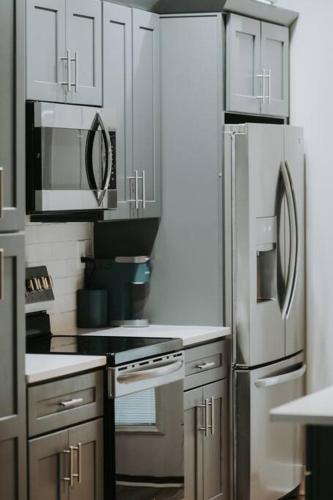 a kitchen with stainless steel appliances and white cabinets at Winner's Circle in The City in Lexington