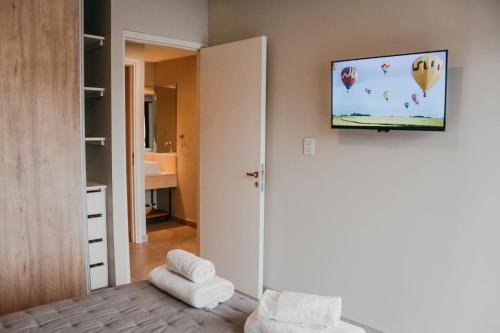 a room with a bedroom with a tv on the wall at 3) Hermoso departamento cómodo y equipado! in Godoy Cruz