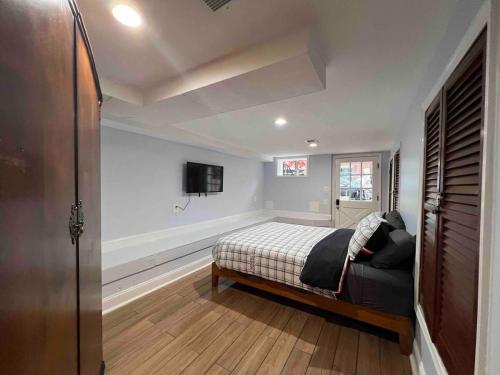 1 dormitorio con 1 cama y TV en la pared en Ultimate Regal 9B Retreat on King St-Walk to metro en Alexandria