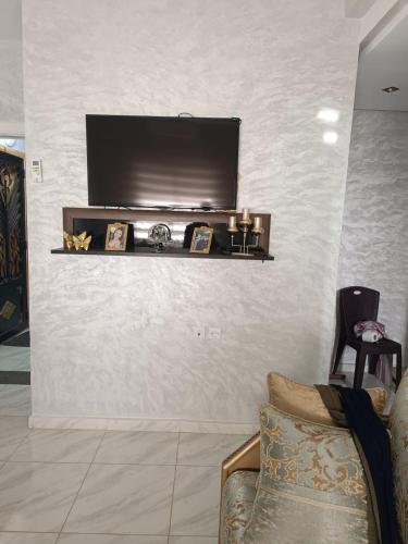 a living room with a television on a wall at Appartement Basatine in Fès