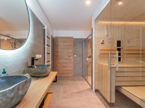 ein Badezimmer mit einem großen Waschbecken und einem Spiegel in der Unterkunft Traumhaus in Donnersbachwald