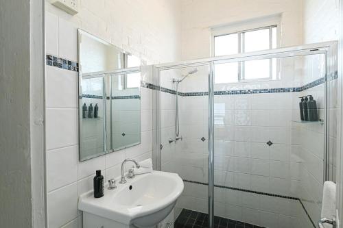 y baño blanco con lavabo y ducha. en Darling St - Charming CBD Abode, Pet Friendly, en Dubbo