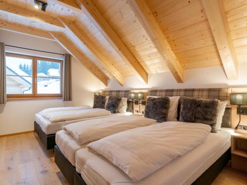 two beds in a room with wooden ceilings at Traumhaus in Donnersbachwald